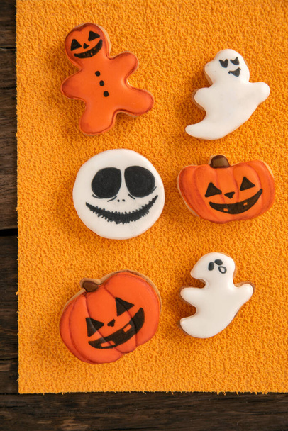 Halloween Zázvorové sušenky ve formě dýně a duchové na oranžovém pozadí. Usmívající se sušenka. Horní pohled - Fotografie, Obrázek