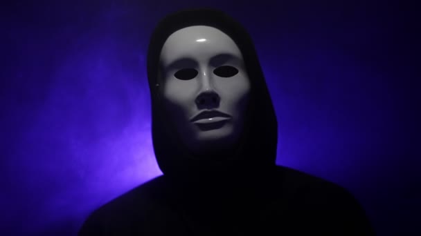 Mann trägt Maske mit Kapuzenpulli auf blauem Hintergrund. - Filmmaterial, Video