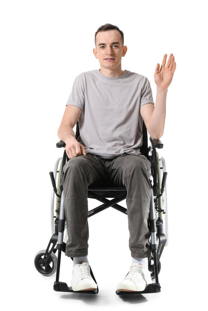 Joven en silla de ruedas saludando mano, aislado en blanco - Foto, imagen