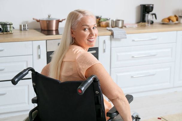 Mature woman with physical disability in kitchen - Photo, Image