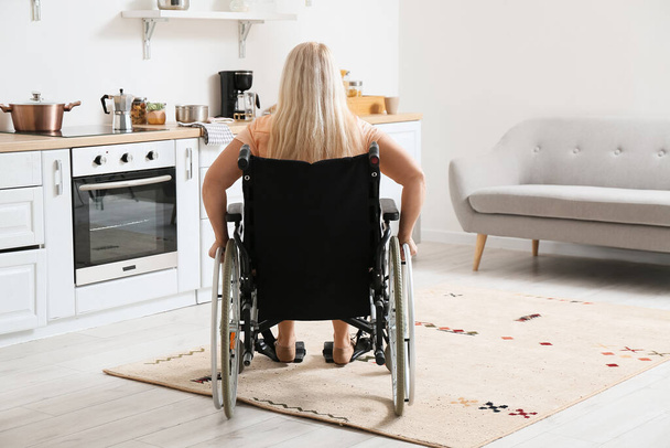 Mulher madura com deficiência física na cozinha, vista traseira - Foto, Imagem