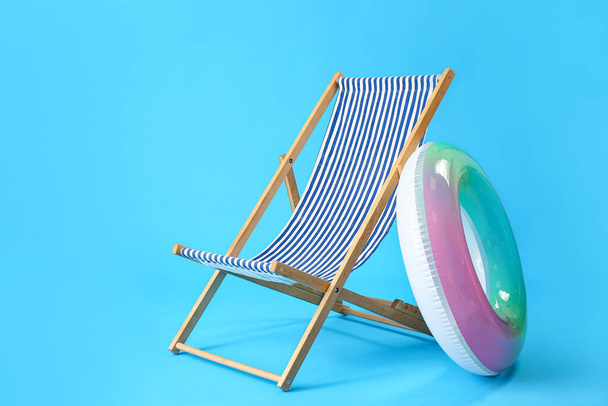 Deck chair and inflatable ring on light blue background - Photo, Image