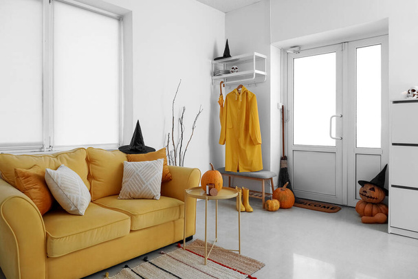 Інтер'єр залу, прикрашений на Хеллоуїн жовтим диваном і платтям
 - Фото, зображення