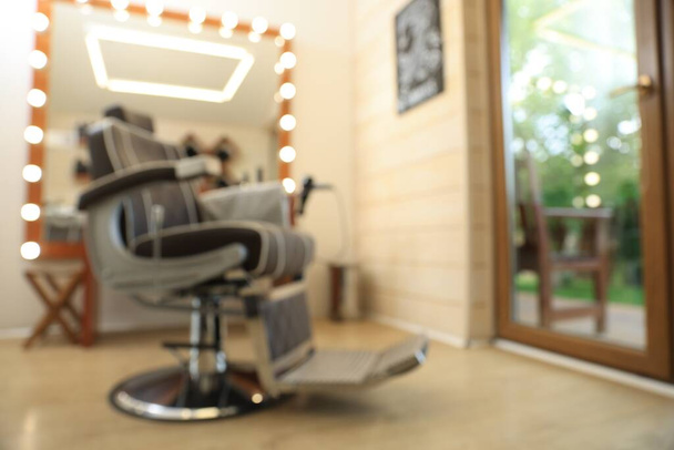 Blurred view of stylish barbershop interior with hairdresser workplace - Fotó, kép