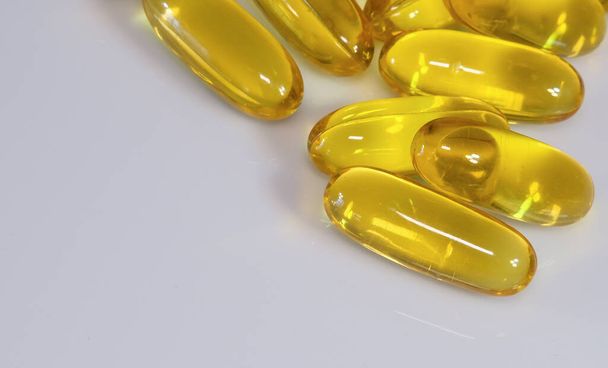 Cápsulas de vitamina E sobre fondo blanco
 - Foto, imagen