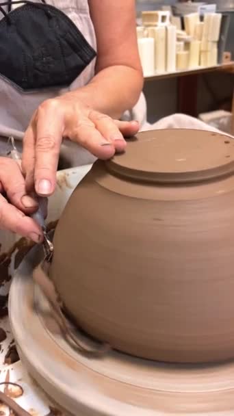 Potters mestariluokka Keramiikka pyörä taidetta tehdä keramiikkaa keittiötarvikkeita Naisten kädet katkaista ylimääräinen savi lastut ovat näkyvissä kuin suklaasta virtaa putoamasta kuin Serpentine - Materiaali, video