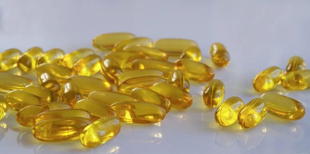 Cápsulas de vitamina E sobre fondo blanco
 - Foto, Imagen