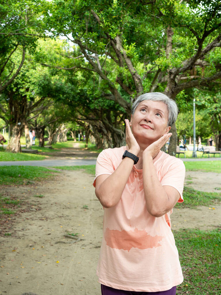 Портрет щасливої старшої дорослої літньої азіатки 60-х років, дивлячись на копійку в парку
. - Фото, зображення