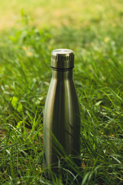 Water bottle. Reusable steel thermo water bottle on green grass. Sustainable lifestyle. Plastic free zero waste free living. Go green Environment protection. Health-conscious. Steel thermo water - Photo, Image