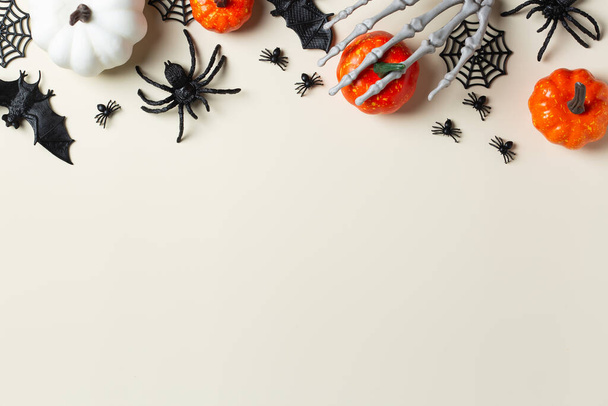 Feliz Halloween, truco o trato tarjeta de felicitación con murciélagos, telaraña, araña, cráneo y calabazas. Composición de la disposición plana, plantilla de maqueta de espacio de copia  - Foto, imagen
