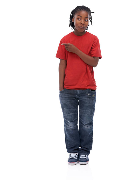 Can you believe this. A young African boy standing agisnt a white background pointing to the side - Photo, Image