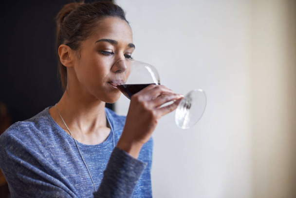 Itt az ideje egy pohár bornak. Egy fiatal nő vörösbort iszik. - Fotó, kép