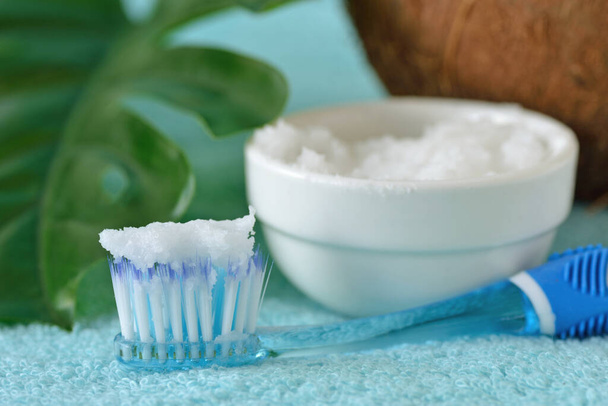 Kokosolie in een kom met tandenborstel - Zelfgemaakte whitening tandpasta - Foto, afbeelding