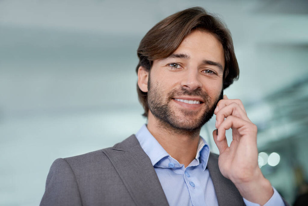 Contacting his clients. A handsome young businessman communicating via cellphone - Fotó, kép