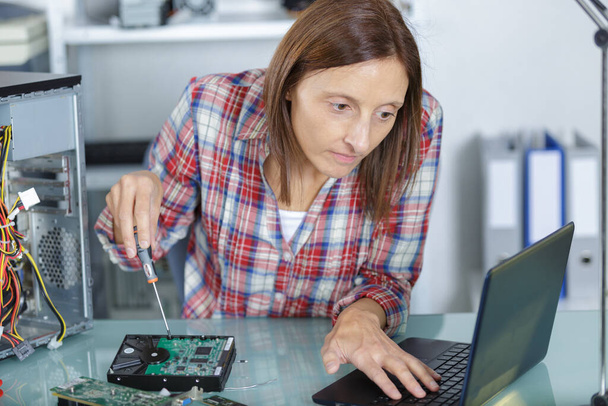 woman learning to fix her computer - 写真・画像