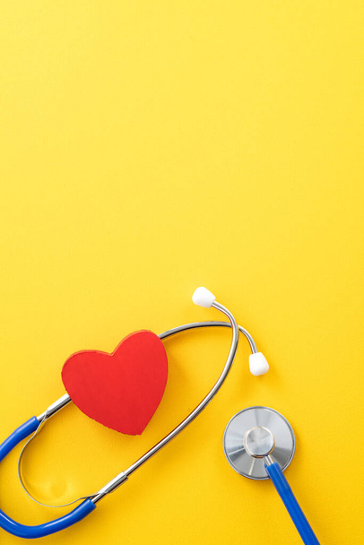 Diagnostic du médecin et concept de conception des soins stéthoscope avec coeur rouge sur fond jaune. - Photo, image