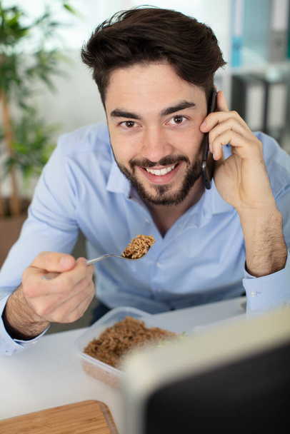 man has business lunch in office talking on mobile - Photo, image