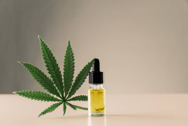 Cannabis sativa konopný list s nádobkou z CBD oleje s kapátkem víčka na bílém pozadí. Legalizovaný koncept marihuany. - Fotografie, Obrázek