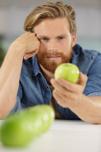manzana verde en una mano de hombre - Foto, imagen
