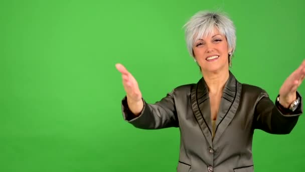 Firmy średniej wieku kobieta przyjmuje z zadowoleniem - zielony ekran - studio - Materiał filmowy, wideo