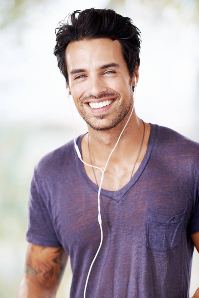 Estás com bom aspecto. Retrato de um homem bonito sorridente ouvindo música com seus fones de ouvido - Foto, Imagem