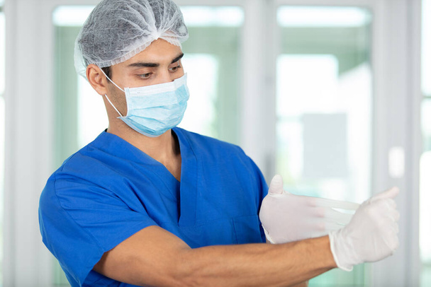 male doctor takes off latex gloves - Zdjęcie, obraz