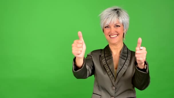 Ділова жінка середнього віку показує великі пальці за погодженням - зелений екран студія
 - Кадри, відео