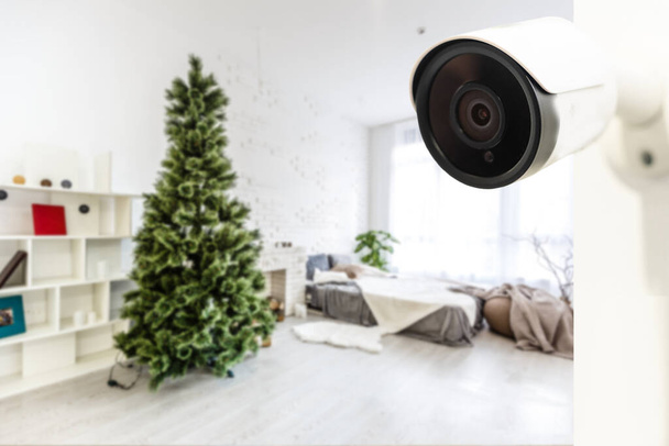 Primer plano Captura de objetos de una cámara de vigilancia Wi-Fi moderna en una pared blanca en un acogedor apartamento. - Foto, imagen