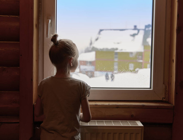 Thirst for adventure. Little girl standing near window and looking aside and enjoying sunny day. Feel free - Φωτογραφία, εικόνα
