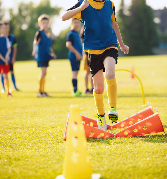 School Boy Running Slalom Track Between Training Poles and Jumping Over Cones. Teenage Football Players Running on Training Camp. Soccer Training Equipment - Photo, Image