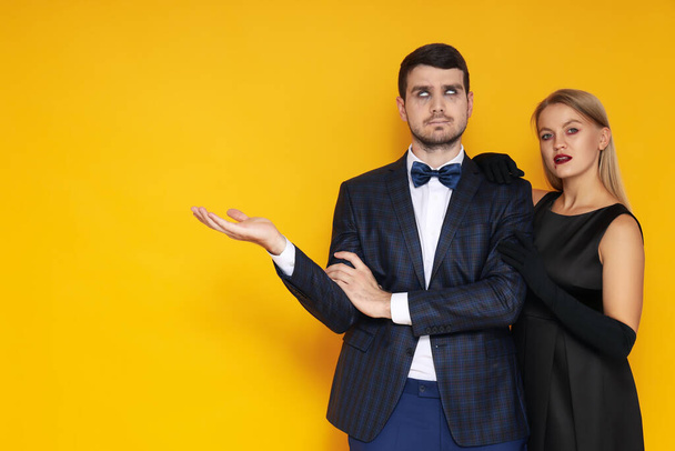 Concept of Halloween, young man and woman on yellow background - Photo, Image