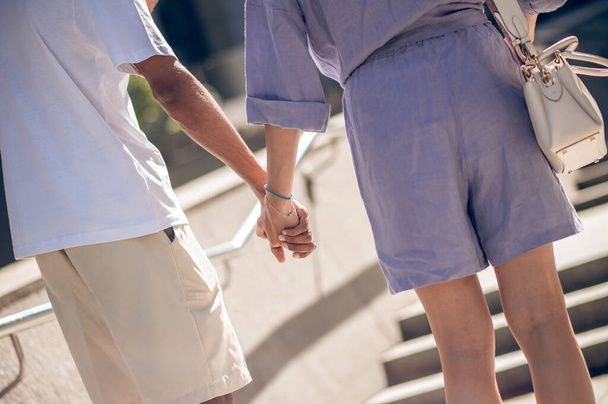 Hand in hand. Close up picture of a couple walking hand in hand - 写真・画像