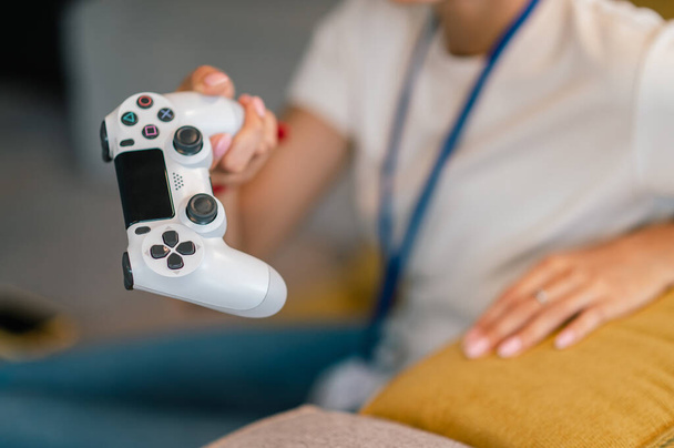 Online game. Young woman with a game pad in hand playing online game - Photo, Image