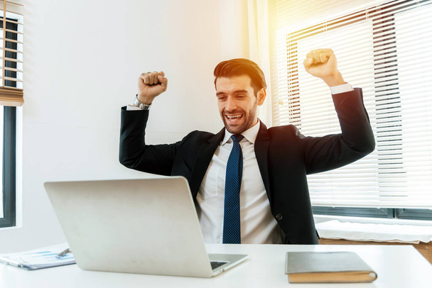 motion of business man employee excited and raising hands up for celebrating with laptop computer in office company, investment, digital online marketing and financial business, technology concept - Foto, Imagen