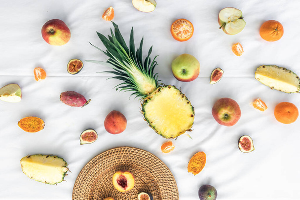 Fruity background with cut pineapple and other exotic fruits, top view. - Φωτογραφία, εικόνα