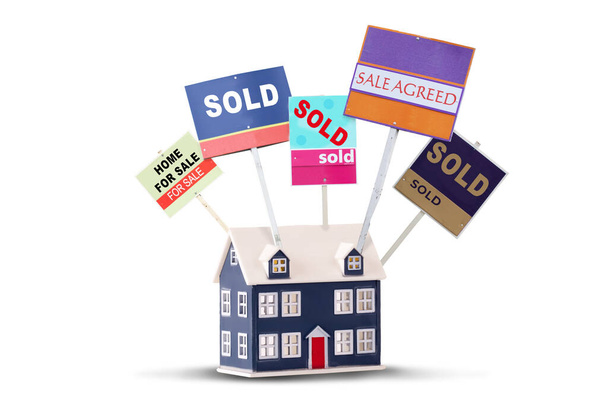 Agente immobiliare casa segni in vendita e venduto su una casa giocattolo isolato su uno sfondo bianco - Foto, immagini