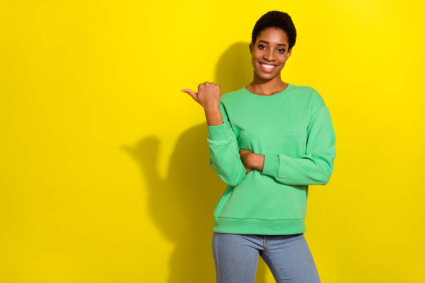 Photo of cute beautiful short hair person dressed casual pullover pointing thumb empty space isolated yellow color background. - Фото, зображення