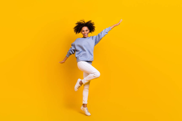 Full body portrait of cheerful satisfied person jumping raise hands rejoice isolated on yellow color background. - Valokuva, kuva