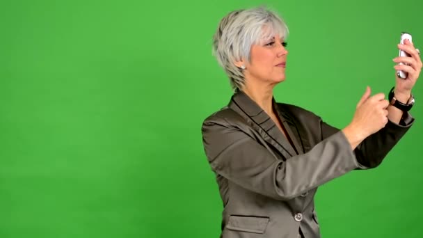 Fotografias de mulher de meia-idade de negócios com telefone (smartphone) - tela verde - estúdio
 - Filmagem, Vídeo