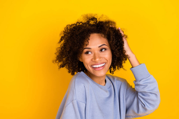 Portrait of cheerful pretty person toothy smile hand touch hair head look empty space isolated on yellow color background. - Foto, imagen