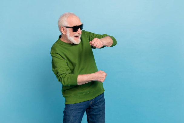 Portrait of overjoyed satisfied aged man dancing clubbing spend weekend isolated on blue color background. - 写真・画像