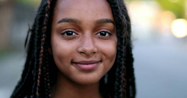 ヒスパニック系の黒の十代の女の子の笑顔に直面する。ブラジルの幸せな子供 - 写真・画像