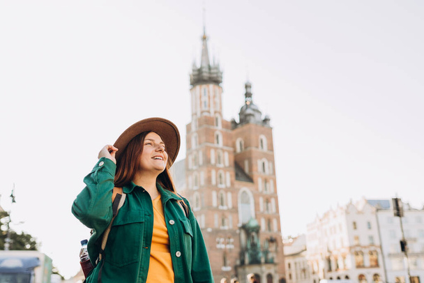 Famosa cattedrale alla luce del sole, Donna turistica in Piazza del Mercato a Cracovia, Viaggiare in Europa in autunno. Basilica di Santa Maria - Foto, immagini