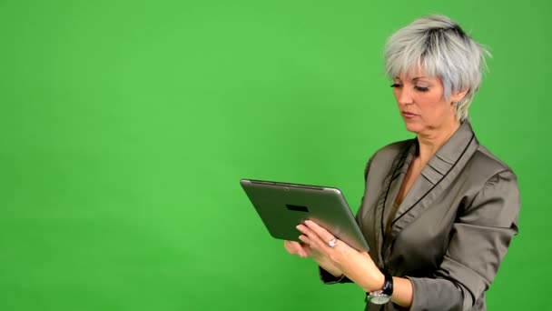 Business middle aged woman works on tablet - green screen - studio - Footage, Video