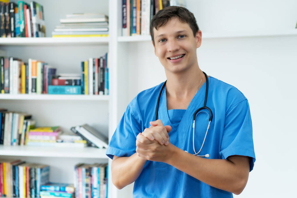Happy caucasian male nurse or doctor with copy space at office of hospital - Photo, Image