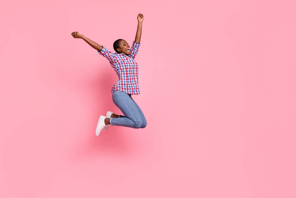 Full size profile photo of overjoyed astonished girl jump raise fists empty space isolated on pink color background. - Фото, изображение