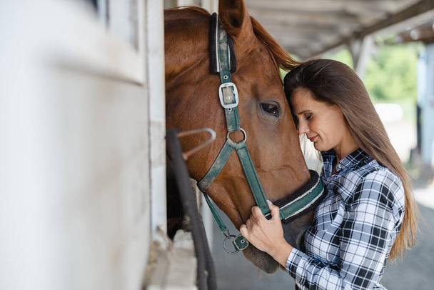 Junge Frau mit Pferd im Stall - Foto, Bild