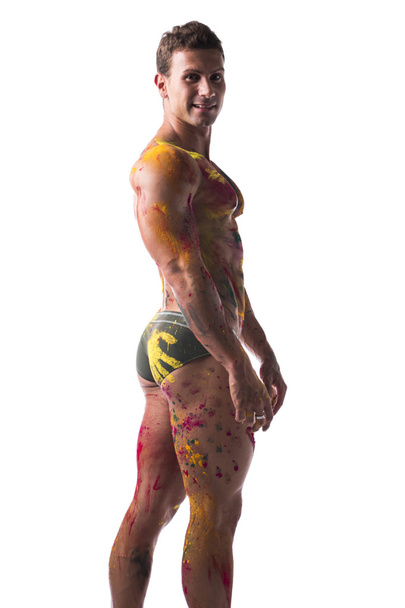 Muscular young man shirtless with skin painted with Holi colors - Foto, Bild