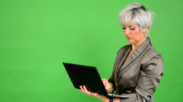 Mulher de meia-idade de negócios trabalha em notebook (de pé) - tela verde - estúdio
 - Filmagem, Vídeo