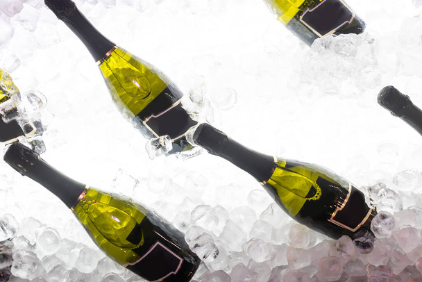 botellas de vino espumoso en hielo. - Foto, Imagen